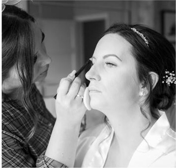 Black and white photo of a bride having her make-up done